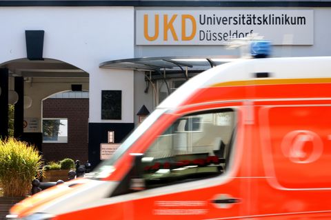 Am Haupteingang zum Universitätsklinikum Düsseldorf fährt ein Krankenwagen vorbei