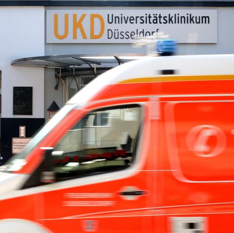 Am Haupteingang zum Universitätsklinikum Düsseldorf fährt ein Krankenwagen vorbei