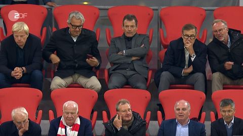 Zehn Funktionäre des FC Bayern sitzen dich beieinander auf der Tribüne