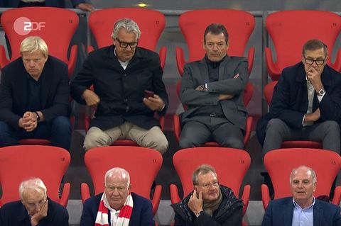 Zehn Funktionäre des FC Bayern sitzen dich beieinander auf der Tribüne