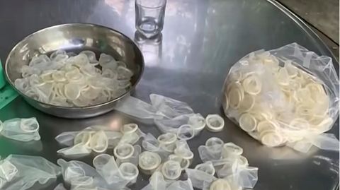 Auf einem Edelstahl-Tisch liegen in einer Metallschüssel und in einem Plastiksack Kondome, die wieder verkauft werden sollten