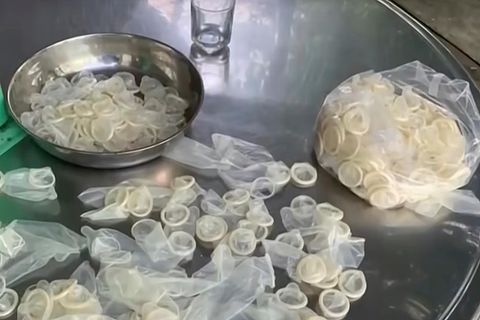 Auf einem Edelstahl-Tisch liegen in einer Metallschüssel und in einem Plastiksack Kondome, die wieder verkauft werden sollten