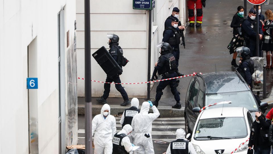 Frankreich, Paris: Polizisten stehen neben der Absperrung des Tatortes