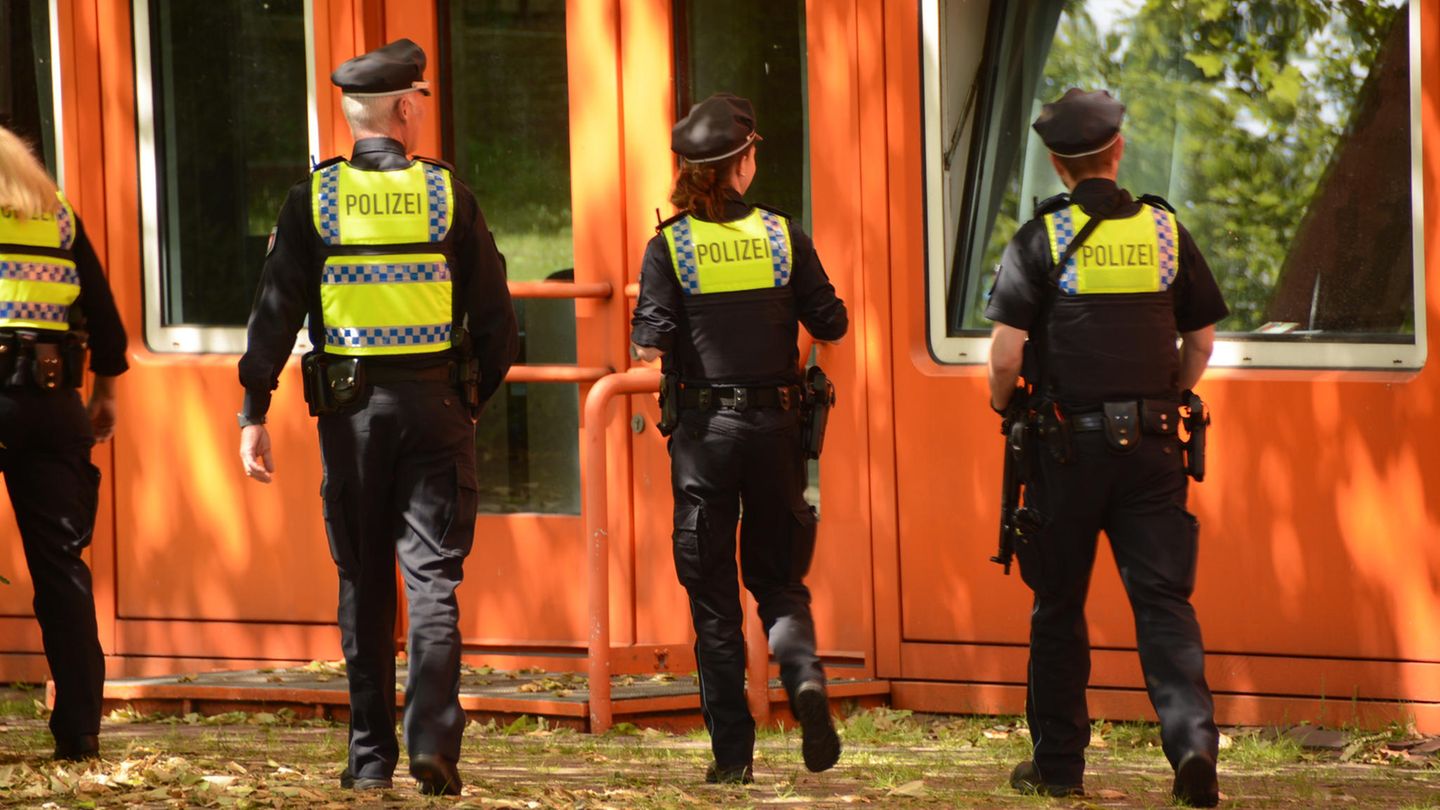 Polizisten gehen auf eine Schule zu