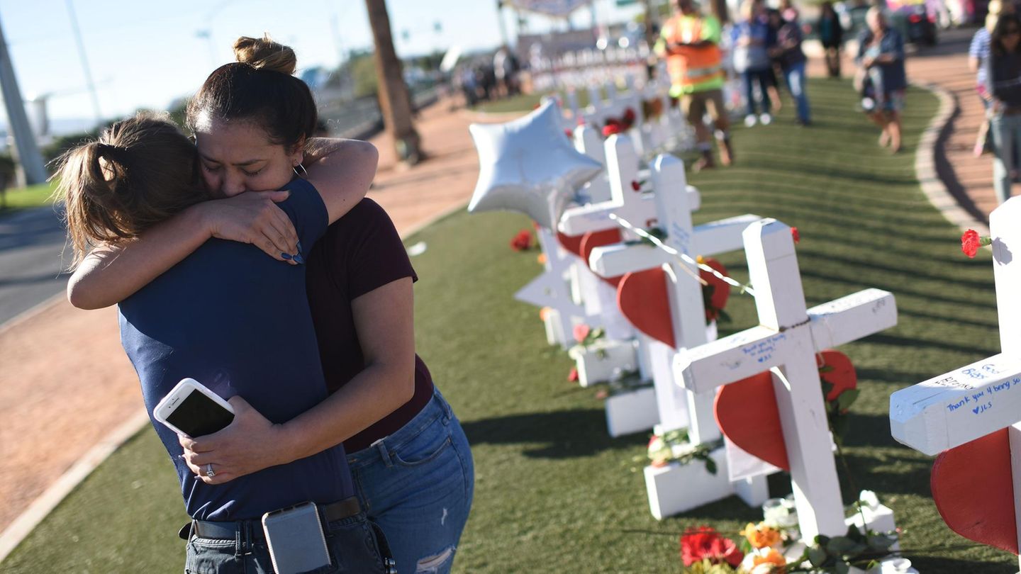 Massaker in Las Vegas: Zwei Überlebende umarmen sich neben den für die Opfer aufgestellten Kreuzen