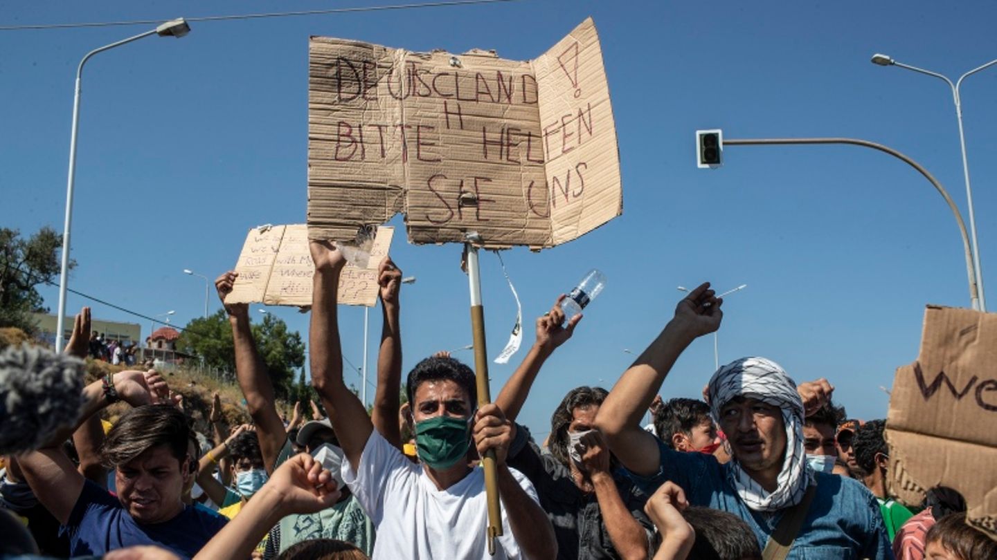 Griechenland, Lesbos: Flüchtling hält ein Plakat mit der Aufschrift "Deutschland, bitte helfen Sie uns".