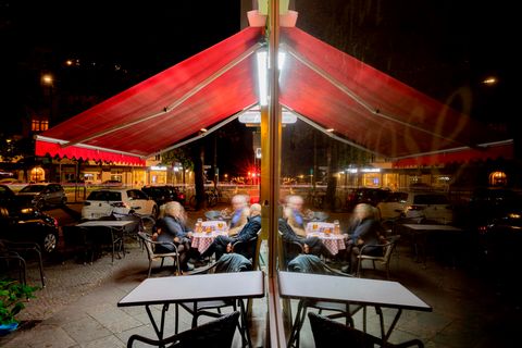 Gäste sitzen am Abend vor einer Kneipe im Berliner Bezirk Wilmersdorf