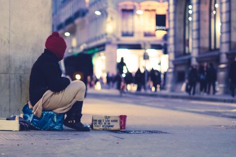 Ein Obdachloser sitzt auf der Straße