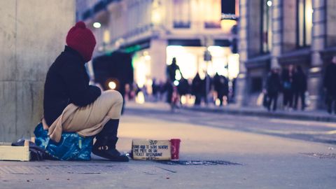 Ein Obdachloser sitzt auf der Straße