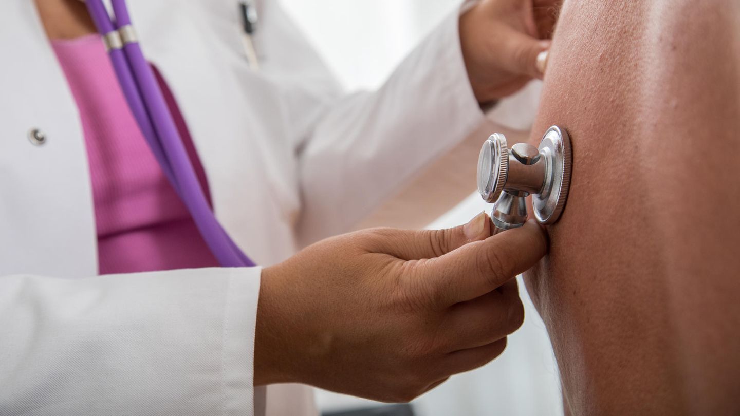 Eine Ärztin hört die Lunge eines Patienten ab