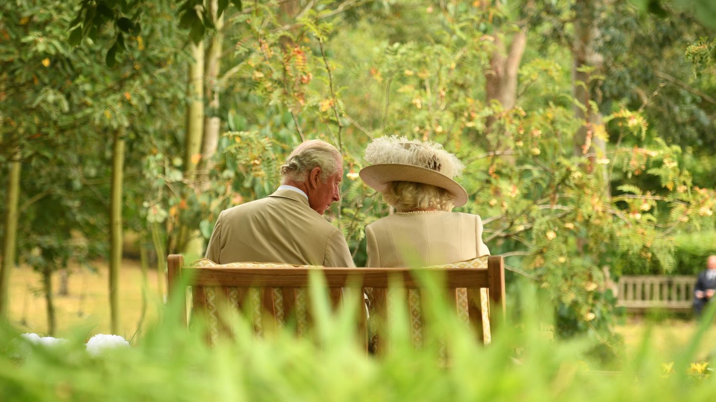 Camilla und Charles auf einer Bank sitzend