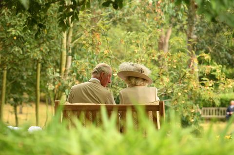 Camilla und Charles auf einer Bank sitzend