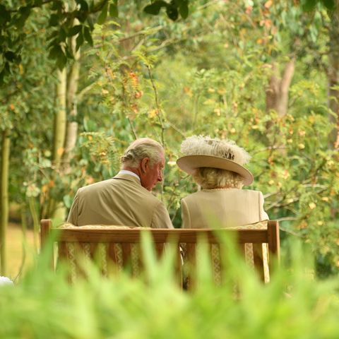 Camilla und Charles auf einer Bank sitzend