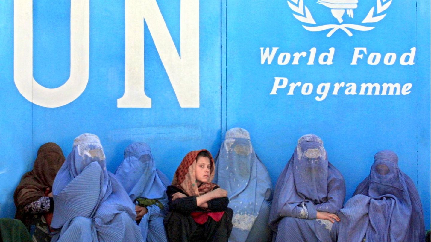 Frauen sitzen vor dem Gebäude des UN-Welternährungsprogramms (WFP) in Kabul und warten auf die Verteilung von Lebensmitteln