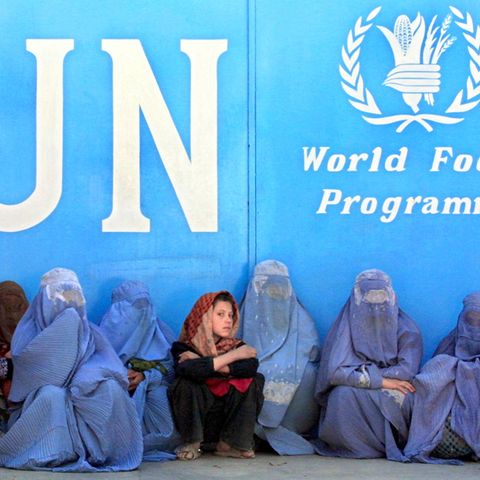 Frauen sitzen vor dem Gebäude des UN-Welternährungsprogramms (WFP) in Kabul und warten auf die Verteilung von Lebensmitteln