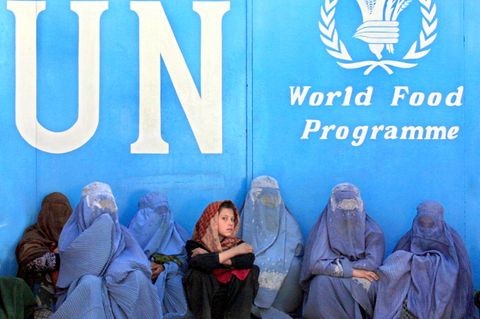 Frauen sitzen vor dem Gebäude des UN-Welternährungsprogramms (WFP) in Kabul und warten auf die Verteilung von Lebensmitteln