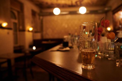 Ein halb geleertes Bier und andere benutzte Gläser stehen kurz nach der Sperrstunde in einer Bar in Neukölln auf dem Tresen. 