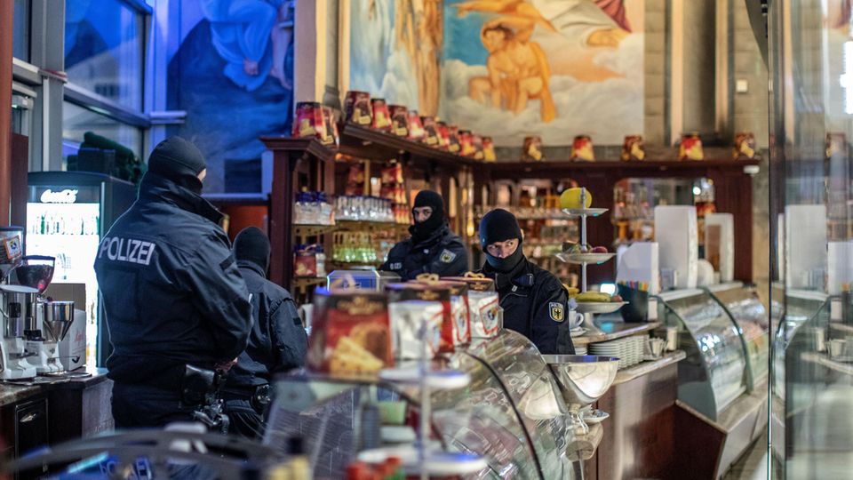 Polizisten stehen in einem Eiscafé im Citypalais in der Duisburger Innenstadt