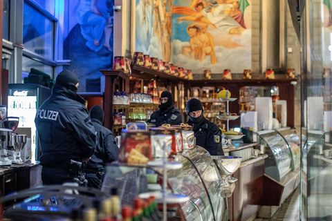 Polizisten stehen in einem Eiscafé im Citypalais in der Duisburger Innenstadt