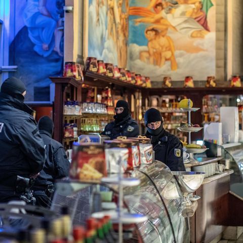 Polizisten stehen in einem Eiscafé im Citypalais in der Duisburger Innenstadt