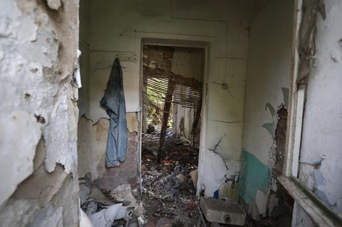 Der Blick durch ein Fenster zeigt den Innenbereich eines Gebäudes, in dem die Leiche eines Mädchens gefunden wurde.