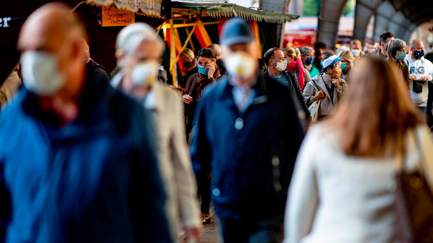 Menschen tragen auf einem Hamburger Wochenmarkt zum Schutz vor dem Coronavirus eine Mund-Nasen-Schutz