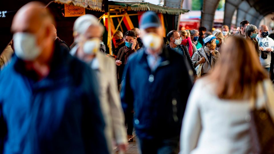 Menschen tragen auf einem Hamburger Wochenmarkt zum Schutz vor dem Coronavirus eine Mund-Nasen-Schutz