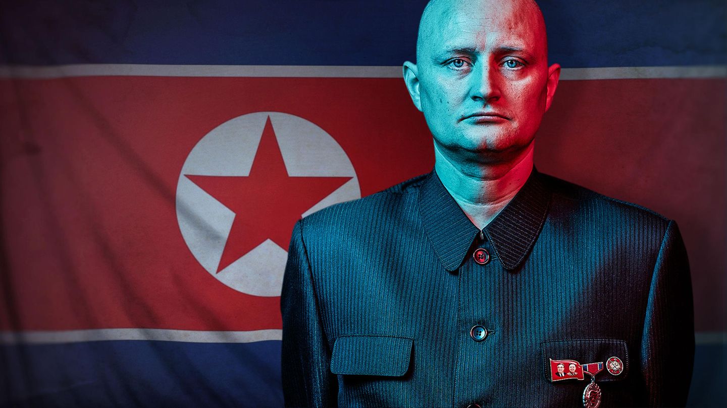 Ulrich Larsen vor einer Flagge von Nordkorea