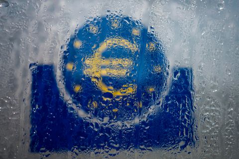 Wasser hat sich an einem gläsernen Schild mit Euro-Symbol niedergelassen