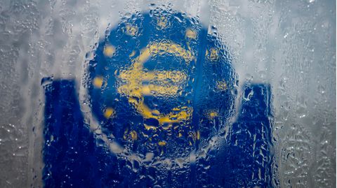 Wasser hat sich an einem gläsernen Schild mit Euro-Symbol niedergelassen