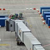 Andere Mitarbeiter simulieren das Beladen der Flugzeugrümpfe mit Gepäckstücken, wuchten die Koffer in Container.