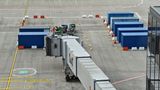 Andere Mitarbeiter simulieren das Beladen der Flugzeugrümpfe mit Gepäckstücken, wuchten die Koffer in Container.
