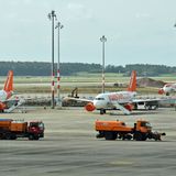 Auf dem Vorfeld übt eine Kolonne von Räumfahrzeugen den Winterbetrieb und schiebt fiktiven Schnee weg. Im Hintergrund hat Easyjet seit Monaten nicht benötigte Jets geparkt.