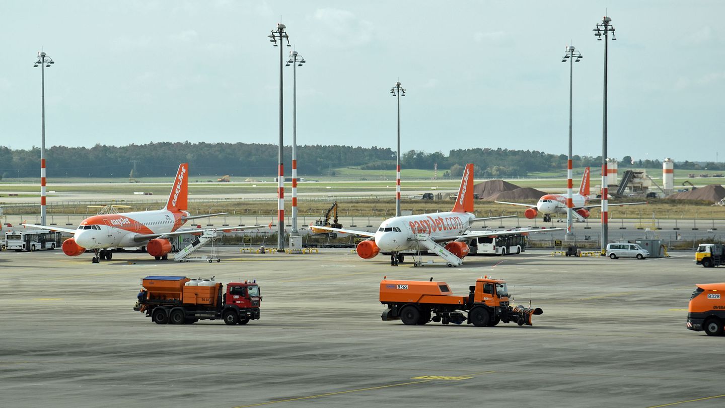 Auf dem Vorfeld übt eine Kolonne von Räumfahrzeugen den Winterbetrieb und schiebt fiktiven Schnee weg. Im Hintergrund hat Easyjet seit Monaten nicht benötigte Jets geparkt.