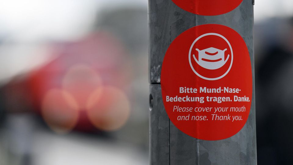 "Bitte Mund-Nase-Bedeckung tragen" steht in deutscher und englischer Sprache auf einem Aufkleber 