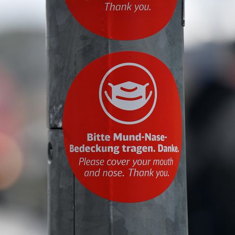 "Bitte Mund-Nase-Bedeckung tragen" steht in deutscher und englischer Sprache auf einem Aufkleber 