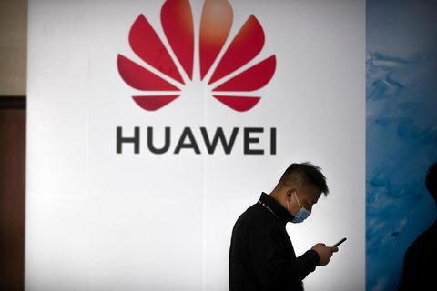 Ein Mann geht an einer Huawei-Werbetafel auf einer Expo vorbei