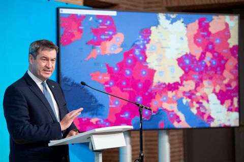 Markus Söder spricht auf einer Pressekonferenz vor einem Monitor mit Corona-Daten