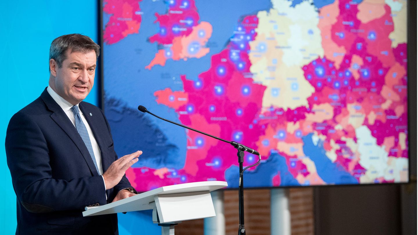 Markus Söder spricht auf einer Pressekonferenz vor einem Monitor mit Corona-Daten