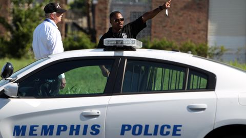 Zwei Männer stehen hinter einem Auto mit der Aufschrift "Memphis Police"
