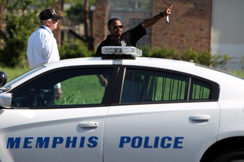Zwei Männer stehen hinter einem Auto mit der Aufschrift "Memphis Police"