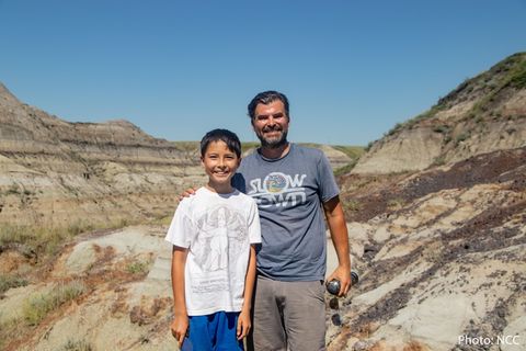 Der zwölfjährige Nathan und sein Vater Dion blicken lächelnd in die Kamera.