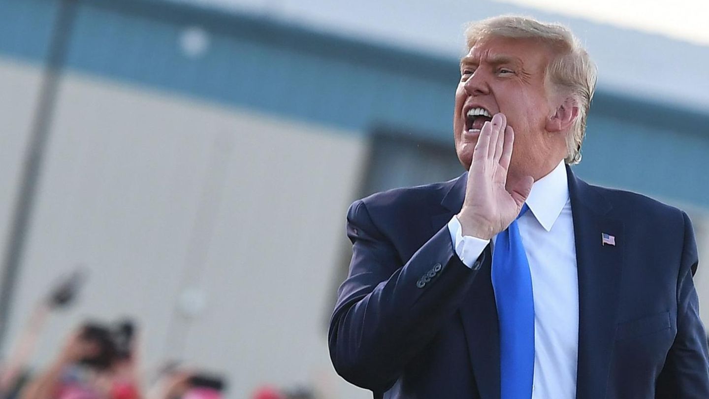 Donald Trump schreit zur Seite mit vorgehaltener Hand