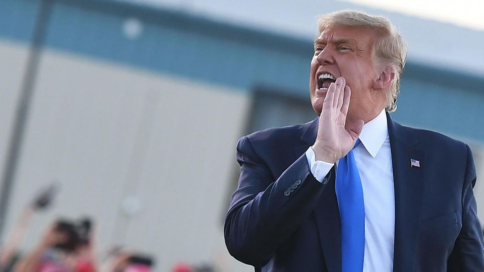 Donald Trump schreit zur Seite mit vorgehaltener Hand