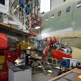 Am "Flügelbauplatz" : Bei diesem Arbeitsschritt werden die Tragflächen am Rumpf fixiert. Der Transport zur nächsten Station erfolgt auf mobilen Werkzeugplattformen.