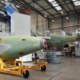 Alles ist beweglich: Zunächst werden die Rumpfteile - die "Heck- und Vordertonne" mit Hilfe eines Nietenroboters verbunden. Im Vordergrund ein Heckstück, in dem die Auxiliary Power Unit (APU) untergebracht ist - das Hilfstriebwerk eines Flugzeuges.