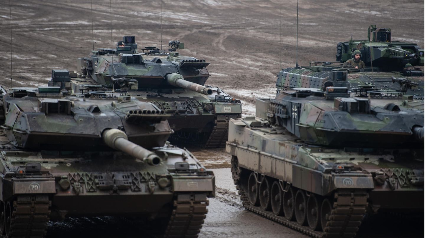Drei Kampfpanzer der Bundeswehr vom Typ Leopard 2A6 und ein Schützenpanzer vom Typ Puma stehen bei einer Übung im Gelände