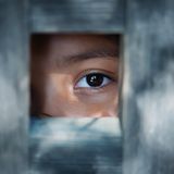 Frau schaut durch ein Loch