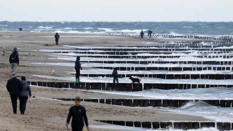Graal-Müritz in Mecklenburg-Vorpommern: Spaziergänger sind am Strand unterwegs, die Strandkörbe sind alle im Winterquartier.