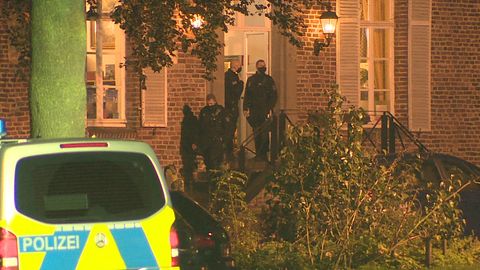 Polizeibeamte gehen in ein Haus auf dem Areal einer Eventagentur in Goch am Niederrhein